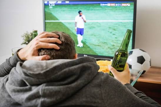 guy-watching-soccer-game-with-green-soda-bottle